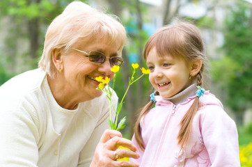 Fototapeta premium girl giving her great grandmother flowers