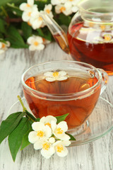 Cup of tea with jasmine, on wooden table, close-up