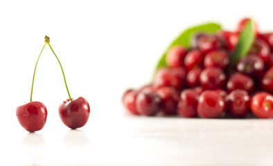 A pair of cherries with group of cherries in the background
