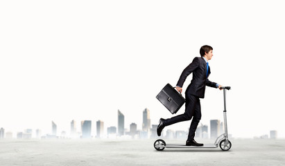 Businessman riding scooter
