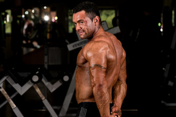 Fototapeta na wymiar muscular bodybuilder showing his side triceps