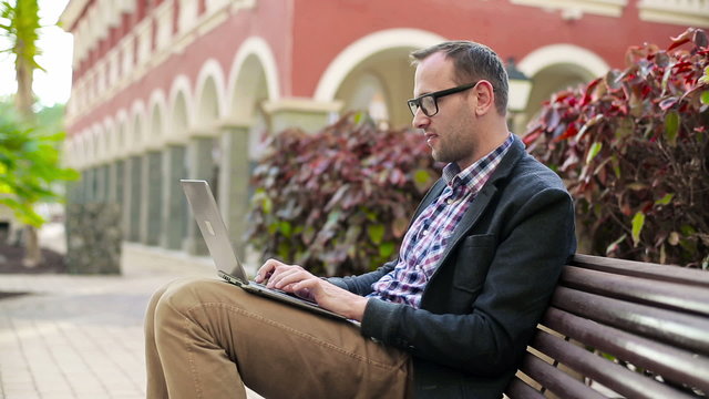 Young man in tourist resort working with laptop computer, steadi