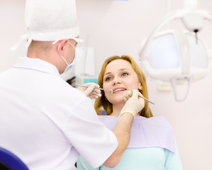 dentist curing a girls teeth in the dental office