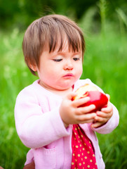 little girl eats an apple