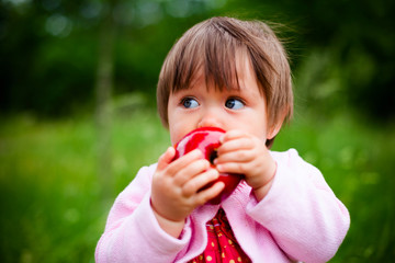 little girl eats an apple