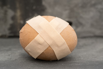 Broken healthcare concept image of plaster on egg