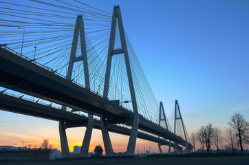 Big suspended bridge during sunrise on blue sky