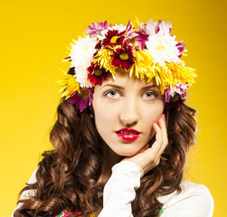 Naklejka premium Portrait of beautiful spring woman, flowers hat. Studio shot
