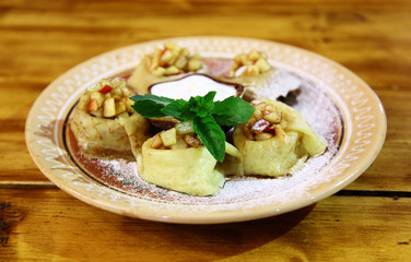 Light breakfast. Dessert. Pancakes with apple and green sprig of