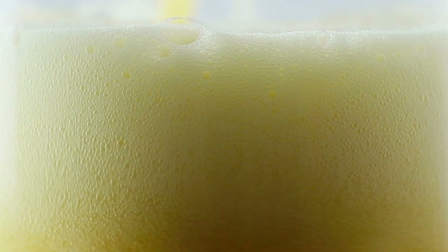 Beer beeing poured into translucent glass, white isolated backgr