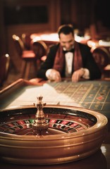 Man in suit and scarf playing roulette in a casino