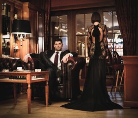 Elegant couple in formal dress in luxury cabinet