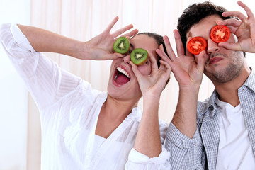 Couple messing around with fruit