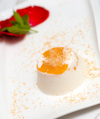 Italian dessert panna cotta on white plate decorated with coconu