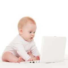 Cute baby with laptop on the white bed
