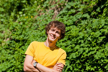 Naklejka na ściany i meble A young curly man in a forest