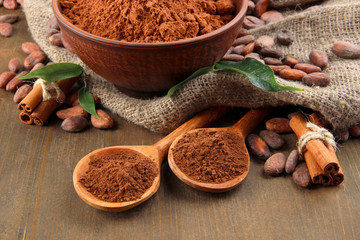 Cocoa powder and cocoa beans  on wooden background