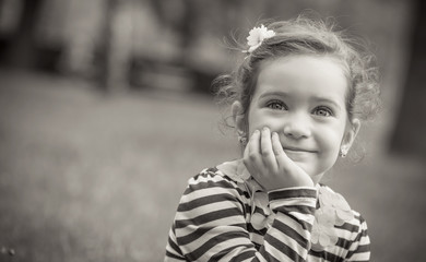 Black and white portrait of cute little girl in a park