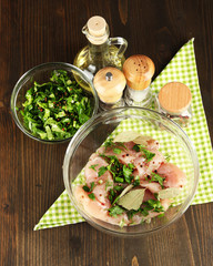 Chicken meat in glass bowl,herbs and spices on wooden table