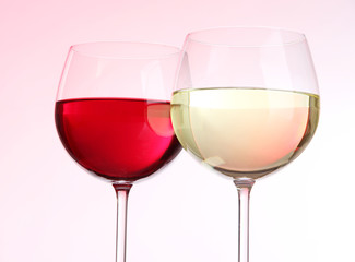 Glasses of wine on light pink tone