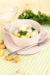 Tender young potatoes with sour cream and herbs in pan
