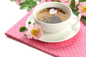 Cup of herbal tea with hip rose flowers, isolated on white