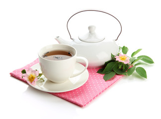 Cup and teapot of herbal tea with hip rose flowers, isolated