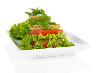 Tasty roasted marrow and tomato slices with salad leaves,