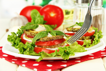 Tasty roasted marrow and tomato slices with salad leaves,