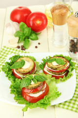 Tasty roasted marrow and tomato slices with salad leaves,