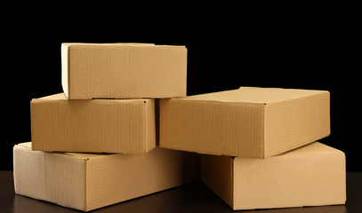 Parcels boxes on wooden table, on black background