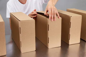 Worker working with boxes at conveyor belt, on grey background