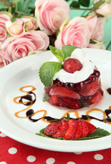 Tasty jelly dessert with fresh berries, on pink roses
