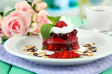 Tasty jelly dessert with fresh berries, on bright background