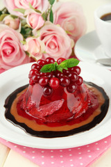 Tasty jelly dessert with fresh berries, on pink roses