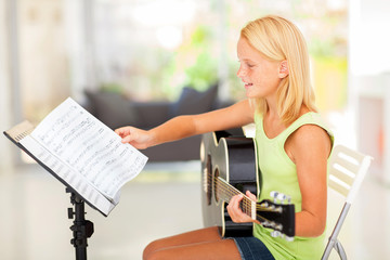 preteen girl playing guitar with musical chords