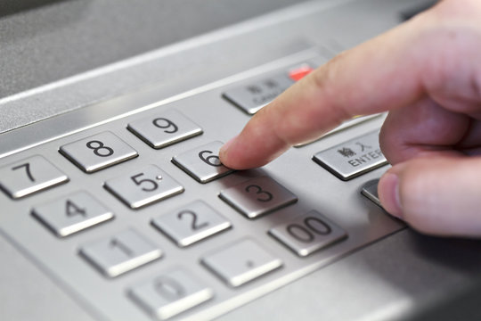 Human hand enter atm banking cash machine pin code