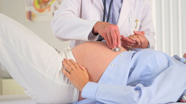 Doctor listening to a pregnant woman's stomach