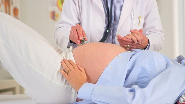 Doctor listening to a pregnant woman's stomach