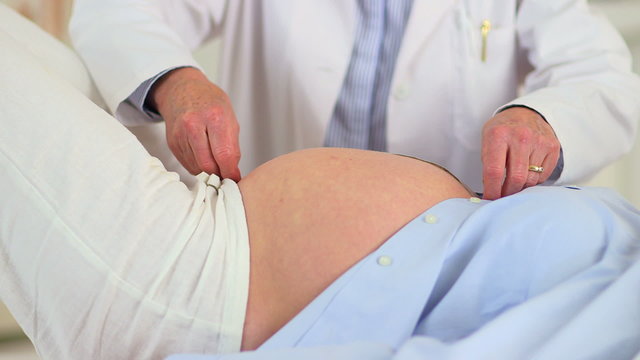 Doctor Examining preganct woman's belly