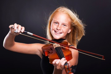cheerful preteen girl playing violin