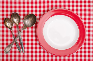 Löffel aus Silber und roter Teller