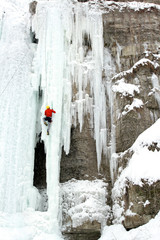 Ice climber struggles up a frozen waterfall.