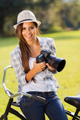 Fototapeta premium happy young woman holding camera outdoors