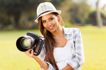 attractive girl holding camera outdoors