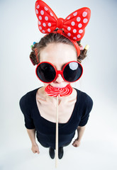cute girl with a big red lollipop and funny sunglasses