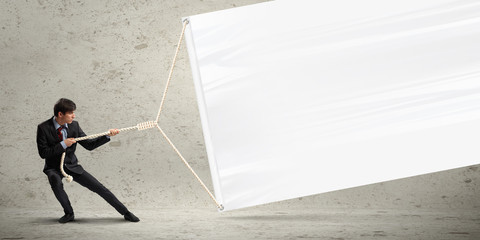 Businessman pulling blank banner