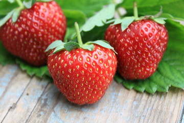 Fresh strawberries with green leaf on old wooden background