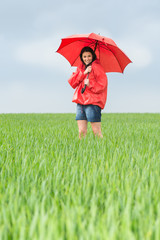 Elated teenage girl holding red umbrella