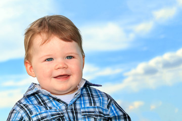 Smiling baby boy with blue eyes close up